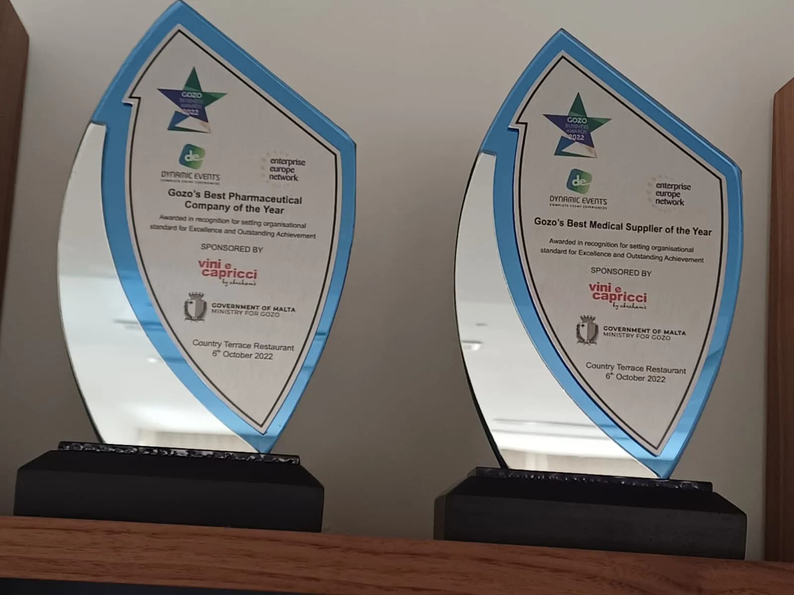 Two Gozo Business Awards 2022 trophies: Gozo's Best Pharmaceutical Company of the Year and Gozo's Best Medical Supplier of the Year.