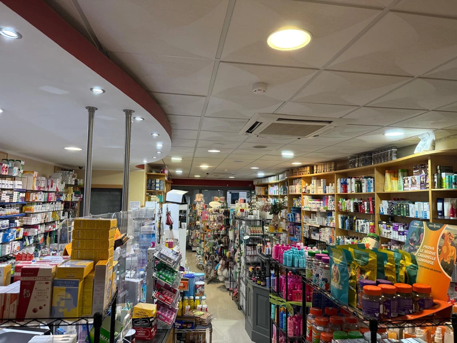 Inside Gozo Chemists: aisles of medicines, supplements and dermo-cosmetics running the length of the shop.