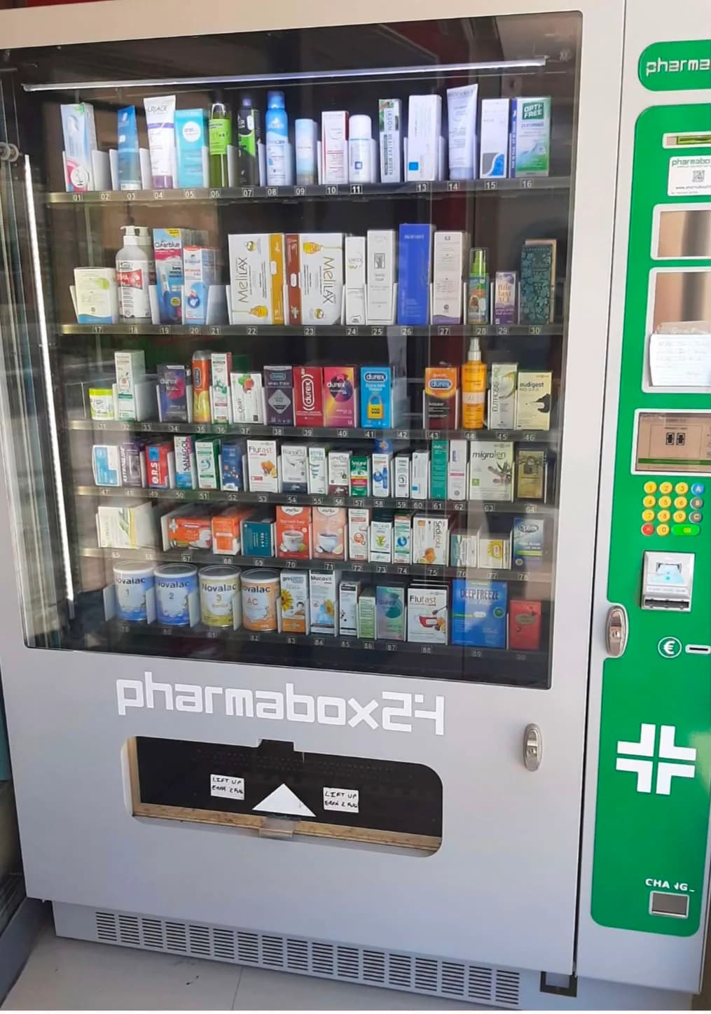 The Pharmabox24 vending machine beside the pharmacy entrance, stocked with medicines and health products.